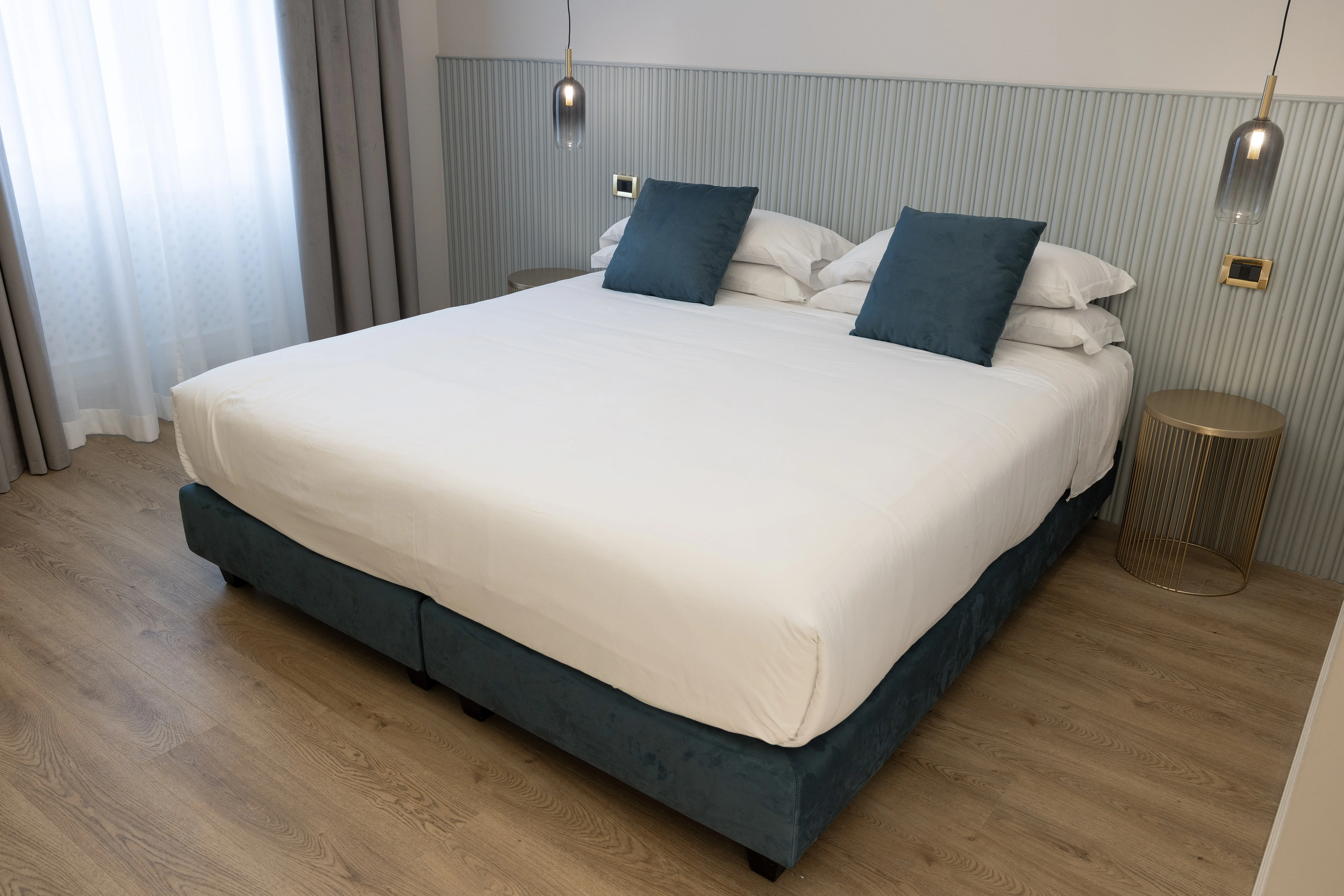 Camera King Deluxe — letto frontale con cuscini blu