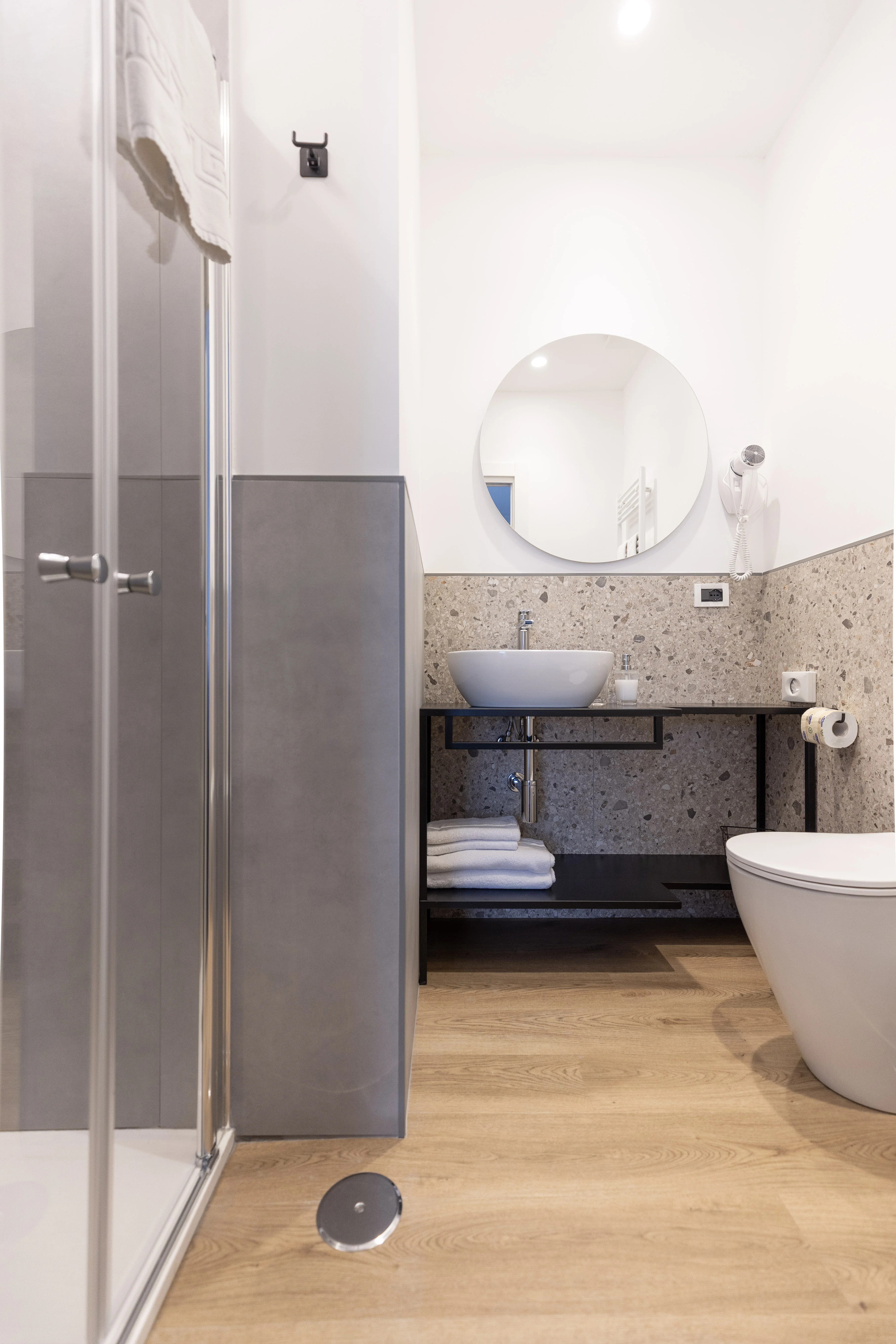 Bagno privato con doccia, lavabo e specchio rotondo