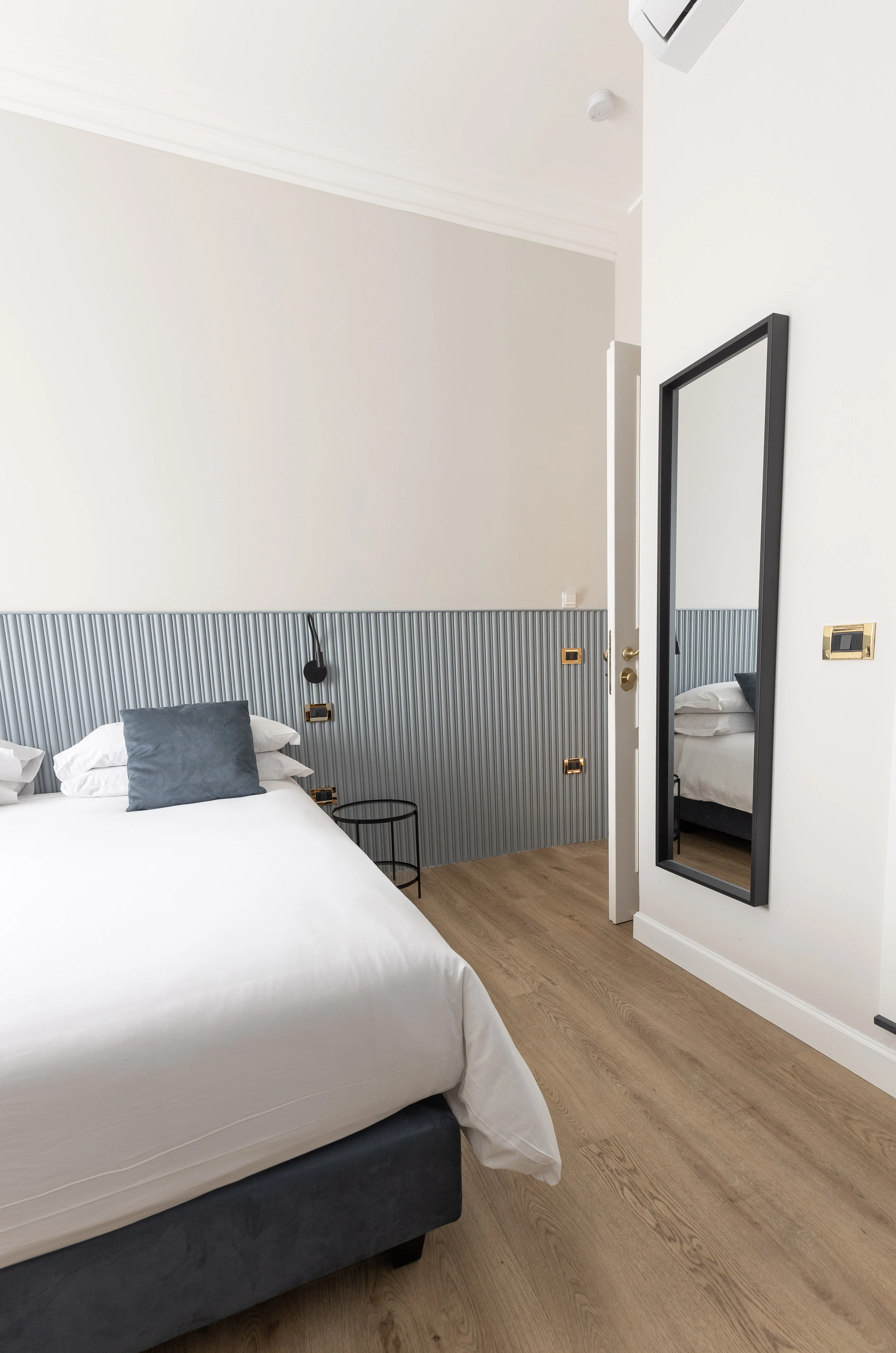 Camera con specchio a parete e aria condizionata