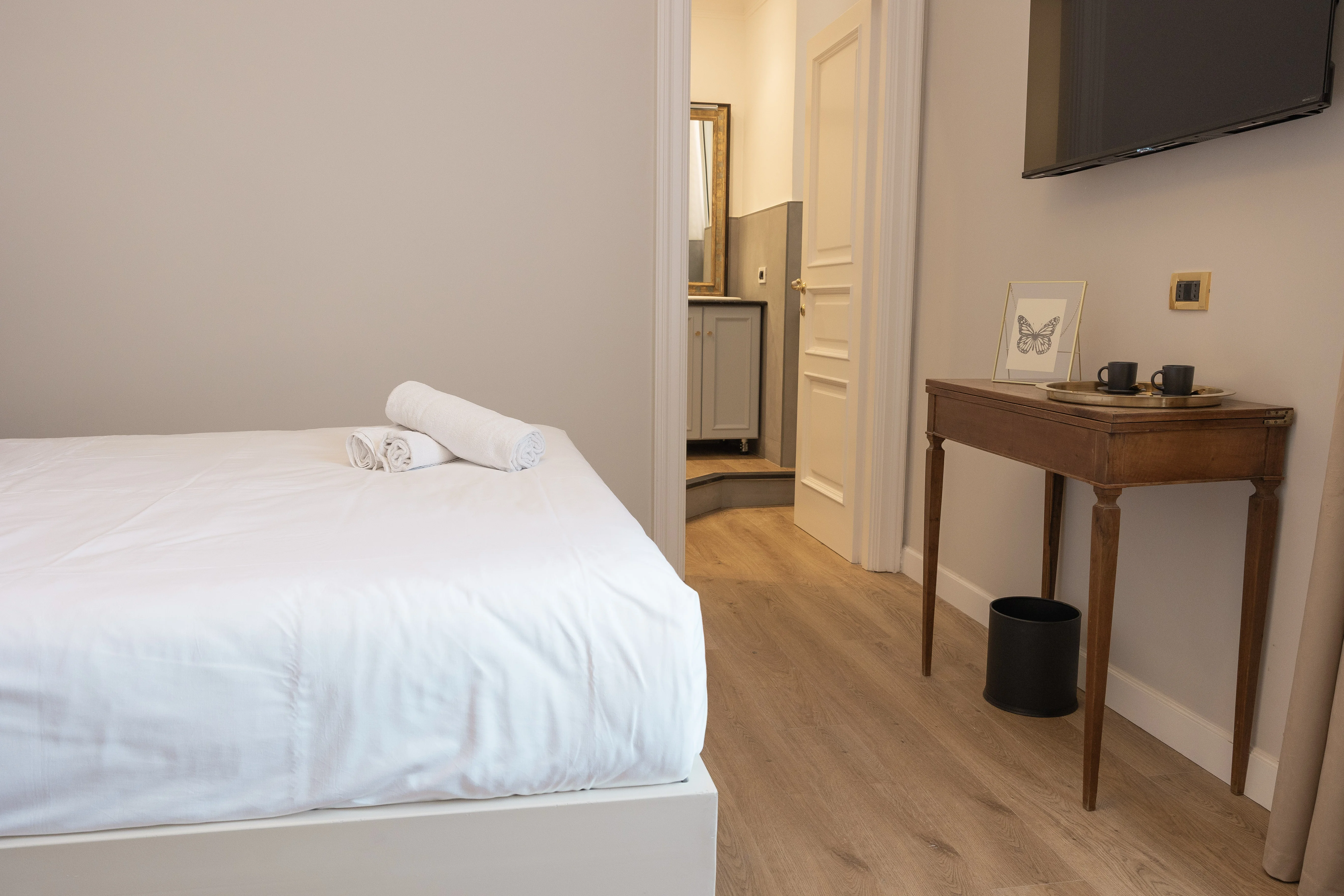 Camera Classic Suite Vista Giardino — vista laterale con console in legno antico e TV