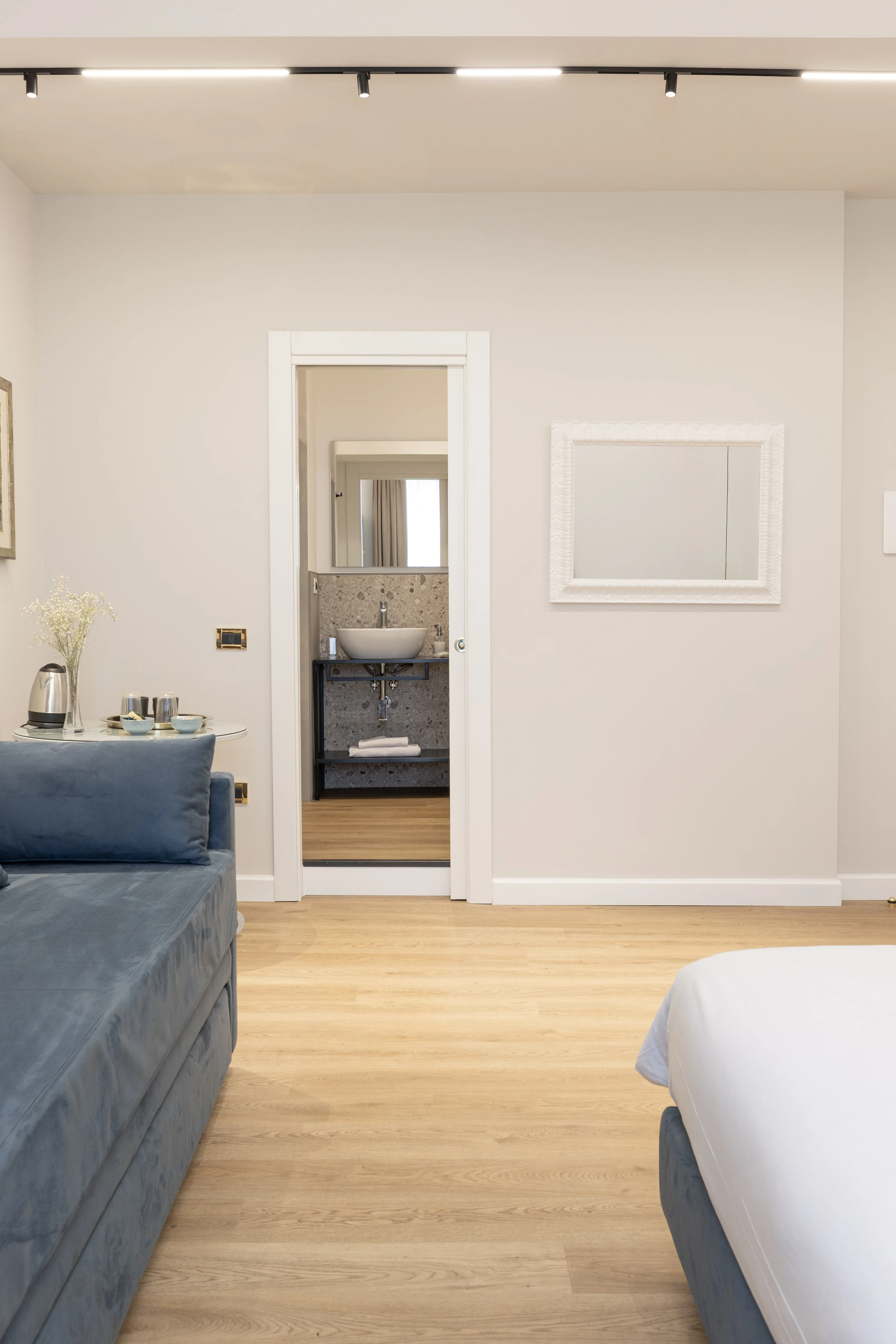 Camera King Suite - Tripla — area living con divano blu in velluto e tavolino con bollitore